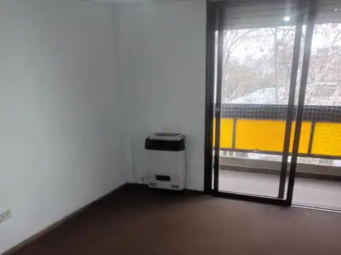 Departamento de un dormitorio al frente con balcones y cocina separada.