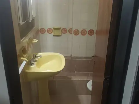 Departamento de un dormitorio al frente con balcones y cocina separada.