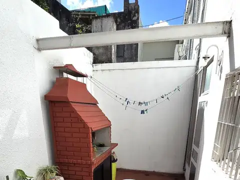 Departamento de pasillo 2 dormitorios con patio. Necochea y Pellegrini.