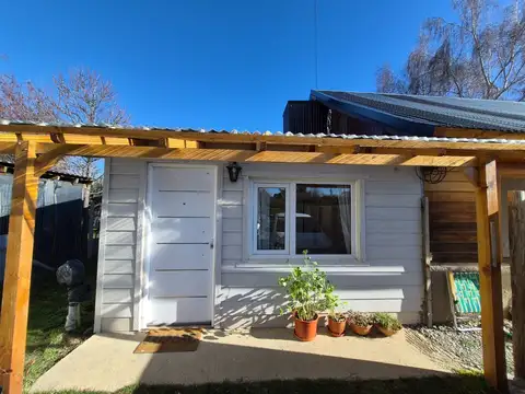 Cálido departamento monoambiente, en una planta, con entrada pasante de auto y patio/jardín.