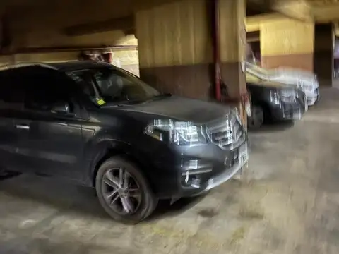 Cochera fija cubierta en edificio de departamentos